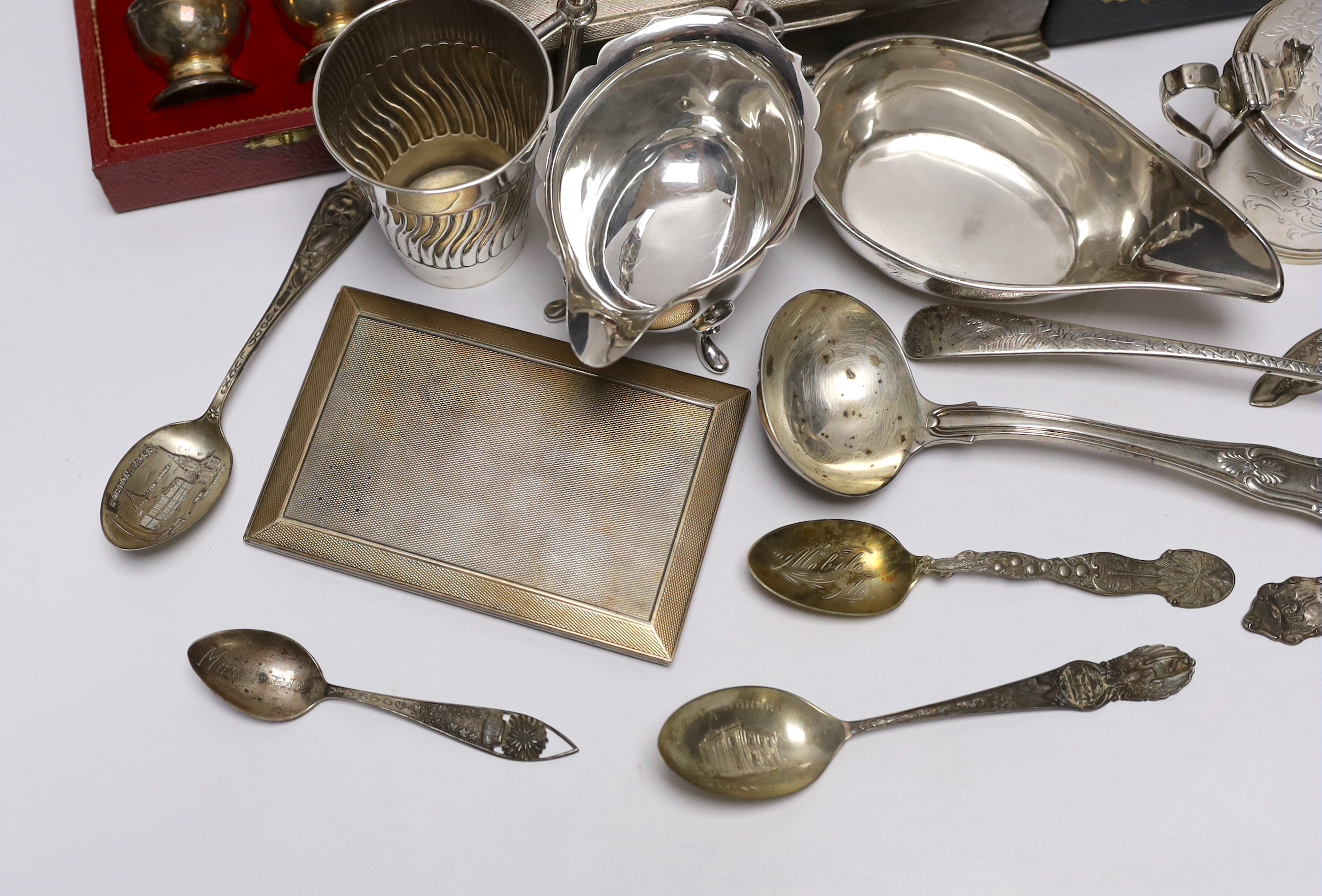 Sundry silver wares including a cigarette box and case, cased condiment set, cased pair of pepperettes and cased set of six teaspoons, sauceboat, Victorian mustard, Victorian mug with angular handle, nine items of flatwa